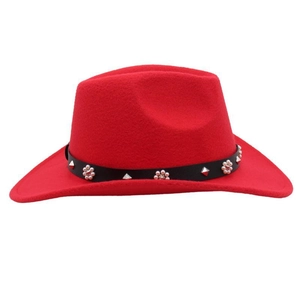 Détail d'un chapeau en feutre rouge avec ceinture en cuir noir et rivets floraux argentés