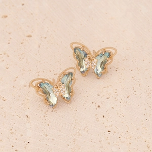 Macro view of butterfly earrings with light teal wings and micro-pave white zircons