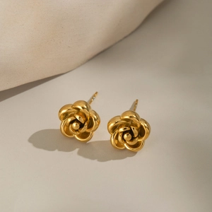 Elegant gold rose flower stud earrings in stainless steel on a minimalist background