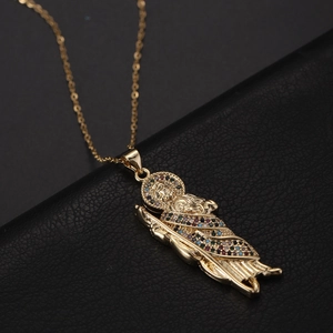 Vue détaillée du pendentif Saint Jude doré avec zircons colorés sur fond de cuir noir texturé