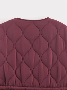 Dettaglio del cappotto trapuntato bordeaux con cuciture a forma di zucca di alta qualità