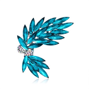Macro shot of silver brooch featuring blue marquise crystals and clear rhinestone bow