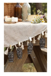 Détail de poids de nappe en fonte en forme de hibou clipsés sur un bord en toile de jute