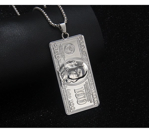 Macro shot of silver stainless steel 100 dollar bill pendant on black leather