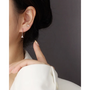Close-up of S925 sterling silver hoop earrings with three small diamonds on earlobe