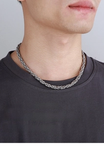 Close-up of men's silver interlocking Byzantine chain necklace on a male model