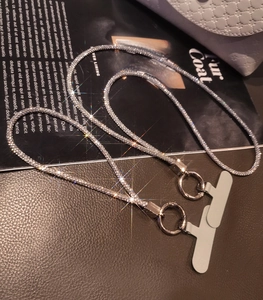 Detailed view of luxury rhinestone phone strap with silver rings and grey connector pads