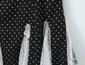 Macro detail of polka dot print fabric with delicate white lace trim and stitching