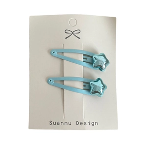 Pair of light blue metallic star hair clips for girls on minimalist paper packaging