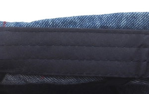 Detail of blue denim beret showing interior black sweatband and reinforced triple stitching