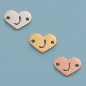 Three heart charms in silver, gold, and rose gold with J engraving and dual side holes