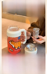 Detail of high borosilicate glass tea cup with stainless steel infuser and cat illustration