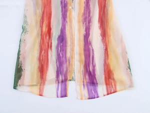 Détail de l'imprimé à rayures aquarelle sur une robe en mousseline semi-transparente