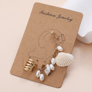Detail of bohemian beach earring with pearls and shells on a gold chain