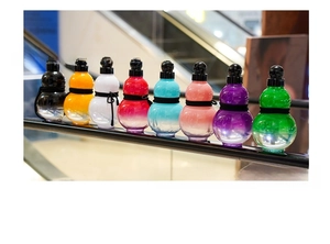 Detailed row of colorful gourd-shaped water bottles with black caps on a handrail display