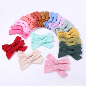 Detailed close-up of colorful linen bow hair clips in various pastel shades for girls