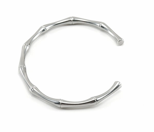 Dettaglio macro del bracciale rigido in acciaio inox argento con design bambù