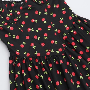 Close-up of cherry print dress featuring V-neckline details and pleated waist design