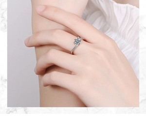 Detail of silver twisted band ring with round cubic zirconia worn on a finger