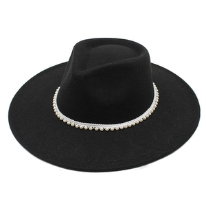 Detailed close-up of a black wide-brim wool hat with elegant white pearl bead trim decoration