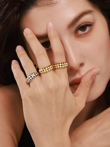Close-up of black and white checkerboard enamel rings in gold and silver finish