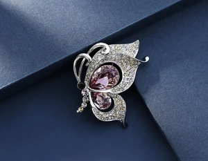 Macro shot of butterfly brooch with silver metal and teardrop-shaped pink crystals