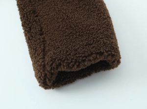 Close-up macro detail of the dark brown thick lamb fleece fabric and sleeve cuff texture