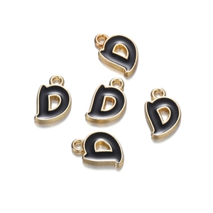 Detail view of five golden alphabet D charms with black enamel finish for DIY jewelry