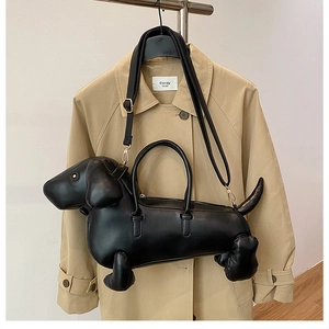 Detail of creative dachshund-shaped handbag in black leather with golden metal clasps