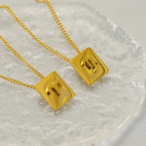 Golden stainless steel zodiac necklace with 3D rectangular pendants on glass background