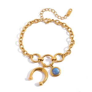 Close-up of gold horseshoe chain bracelet with blue gemstone and K18 hallmark detail