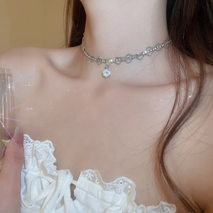 Macro shot of sparkling zircon choker necklace featuring detailed heart patterns and diamonds