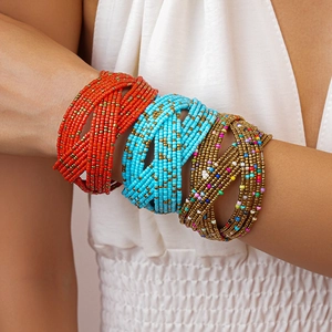 Detail of bohemian multi-layer beaded bangles in turquoise and coral orange on a model