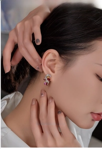 Close-up of elegant crystal tassel earrings with ruby and pink gemstones on a model