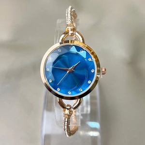 Elegant gold bracelet watch with a blue faceted dial and sparkling rhinestone accents