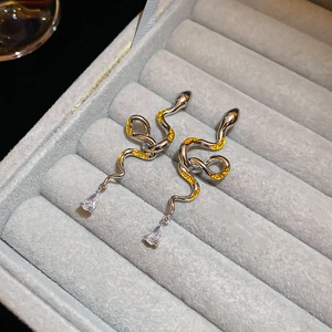 Macro detail of snake drop earrings with yellow enamel and water-drop zircon pendant
