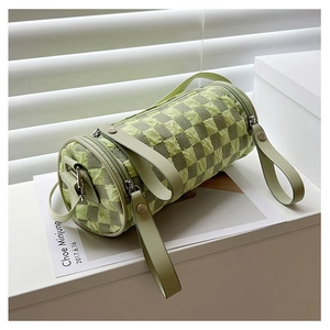 Detail of green checkerboard cylinder bag with pleated texture and leather handles