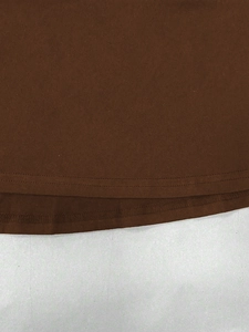 Detalle de cerca de la costura del dobladillo en un vestido ajustado marrón oscuro