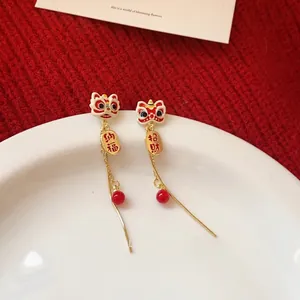 Macro detail of Chinese lion dance tassel earrings with red beads and golden fortune charms