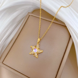Detail shot of a gold starfish necklace featuring an iridescent stone and zircon crystals