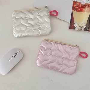 Detailed view of silver and pink quilted heart pouches with smooth zipper handles