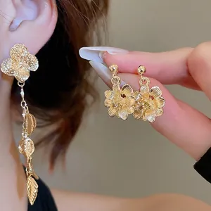 Elegant gold flower stud and leaf tassel earrings with textured clover design
