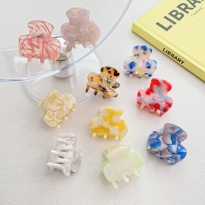 Mini acetate claw clips set with marble patterns and macaron colors on white surface
