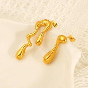 Elegant gold fluid lava style stainless steel drop earrings on white ceramic tray