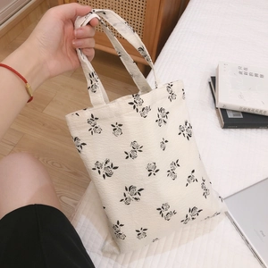 Minimalist white crepe tote bag with black rose floral patterns and fabric handle