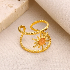 Detailed view of a gold double-layer sunburst ring with an orange gemstone inlay