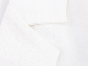 Close-up of white linen-textured fabric showing detailed weave pattern on lapel