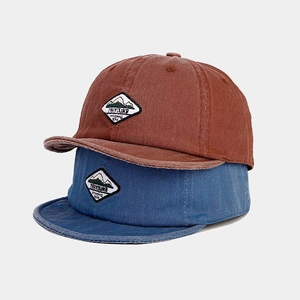 Detailed view of vintage washed cotton baseball caps with embroidered mountain patches