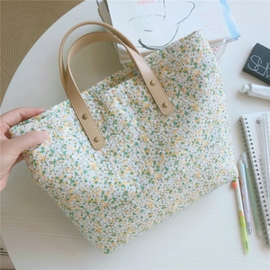 Detailed macro of floral canvas tote bag with premium leather handle and metal rivets