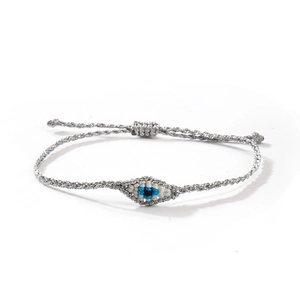 Gros plan du bracelet tressé argenté avec une amulette Evil Eye faite à la main
